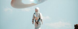 a man in a space suit standing on top of a rock